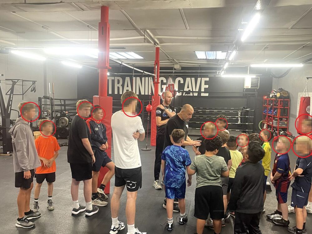 Coaches briefing a group of young students on the gym floor