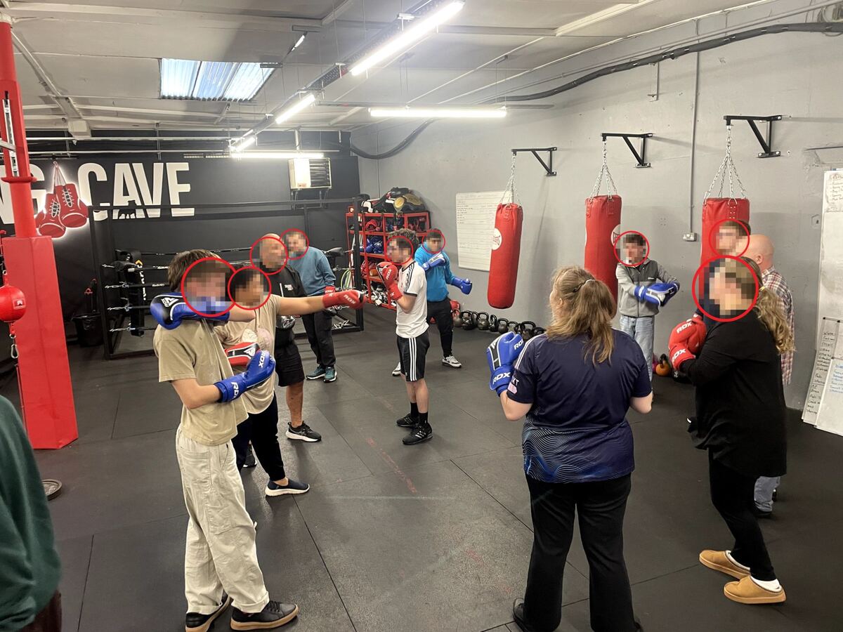 Students and staff practising boxing technique together in the gym